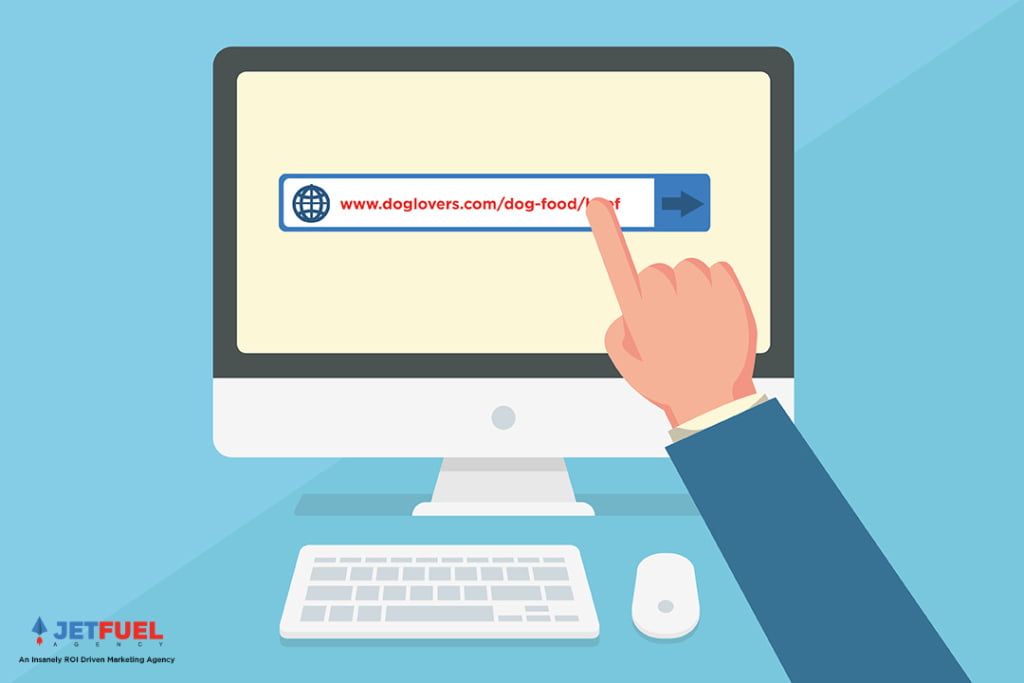 A person pointing at a computer screen with a URL in a search bar.