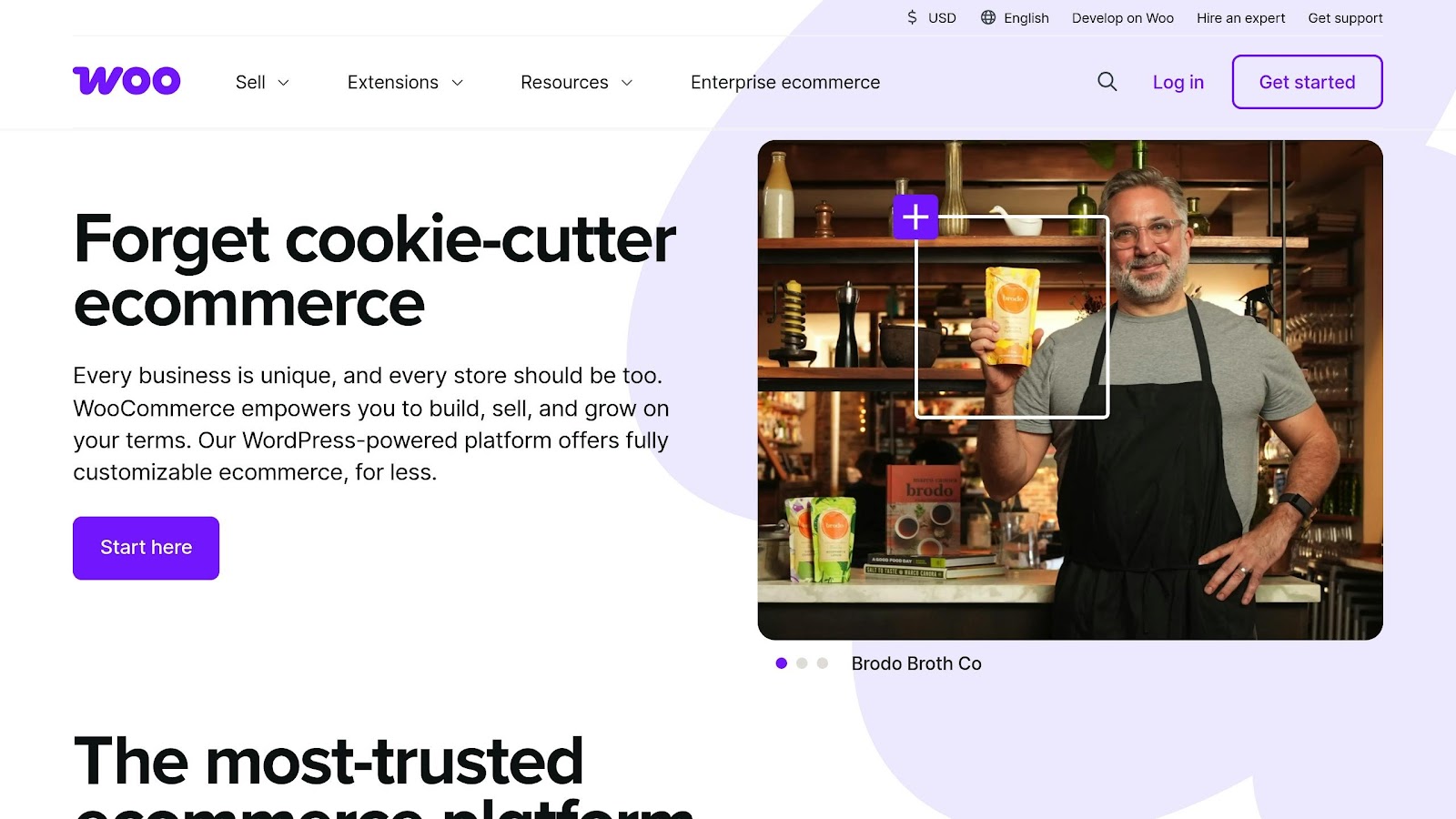 WooCommerce homepage promoting customizable ecommerce solutions. WooCommerce homepage with headline “Forget cookie-cutter ecommerce” and a shop owner holding a product in a store setting.